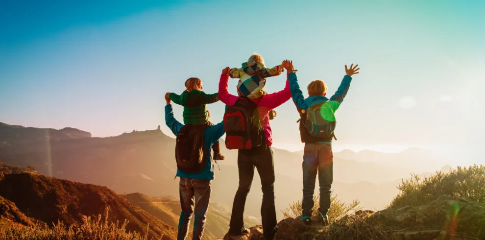 happy family travel in mountains at sunset